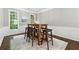 Cozy dining area with a rustic wood table and six barstools next to windows for natural light at 5060 Winship Ct, Alpharetta, GA 30009