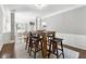 Cozy dining area with a rustic wood table and six barstools, adjacent to the kitchen and living room at 5060 Winship Ct, Alpharetta, GA 30009
