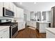 Modern kitchen with white cabinets, stainless steel appliances, granite countertops, and hardwood floors at 5060 Winship Ct, Alpharetta, GA 30009
