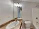 Bathroom featuring single sink vanity with decorative lighting and a shower-tub combo at 514 Jadetree Ln, Atlanta, GA 30349
