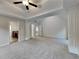 Spacious bedroom featuring tray ceilings, a fan, carpeted floors, and ensuite bath access at 514 Jadetree Ln, Atlanta, GA 30349