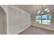 A carpeted dining room featuring paneled walls, baseboard trim, and a chandelier above at 514 Jadetree Ln, Atlanta, GA 30349