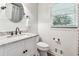 Bright bathroom features marbled countertop, round mirror, and wainscoting at 5860 Riverwood Dr, Sandy Springs, GA 30328
