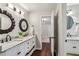 Bright bathroom boasts dual sinks, white cabinetry, decorative mirrors, and marbled countertop at 5860 Riverwood Dr, Sandy Springs, GA 30328