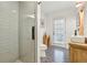 Bright bathroom with a walk-in shower, rustic vanity, and decorative black and white patterned tile floor at 5860 Riverwood Dr, Sandy Springs, GA 30328