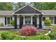 Inviting front porch with stone accents, black pillars, and a meticulously landscaped garden at 5860 Riverwood Dr, Sandy Springs, GA 30328