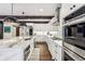 Kitchen with large island, stainless steel appliances, marble countertops, and wood beam accents at 5860 Riverwood Dr, Sandy Springs, GA 30328