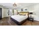 Bright main bedroom with hardwood floors, a large bed, and a modern light fixture overhead at 5860 Riverwood Dr, Sandy Springs, GA 30328