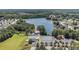 Aerial view of a community pool and tennis courts nestled alongside a serene lake and lush greenery at 855 Lakeside Cir, Covington, GA 30016