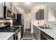Modern kitchen with stainless steel appliances, gas range, and stylish gray cabinets at 855 Lakeside Cir, Covington, GA 30016