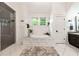 Bright bathroom featuring a soaking tub, shower, and double windows at 132 Olympic Pl, Decatur, GA 30030