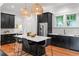 Elegant kitchen boasting dark cabinets, stainless steel appliances, white countertops, and stylish woven light fixtures at 132 Olympic Pl, Decatur, GA 30030