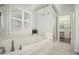 Relaxing bathroom featuring a soaking tub, patterned tile, and a walk-in closet at 402 Lake Point Trce, Canton, GA 30114