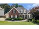Charming two-story brick home with manicured lawn, complemented by mature landscaping and a welcoming entrance at 402 Lake Point Trce, Canton, GA 30114