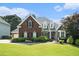 Beautiful red brick home with a well-manicured lawn and mature landscaping at 402 Lake Point Trce, Canton, GA 30114