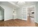 Home office featuring hardwood floors, custom built-ins, and glass french doors leading into kitchen at 402 Lake Point Trce, Canton, GA 30114