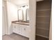 Bathroom featuring a dual sink vanity with shaker cabinets, granite countertops, and a large closet at 4305 Huron Dr, Cumming, GA 30028