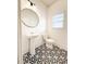Stylish half bathroom with patterned tile floor, pedestal sink, and modern lighting fixture at 4305 Huron Dr, Cumming, GA 30028