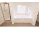 Bright bathroom features a shower and separate tub, with neutral tile floor and ample natural light at 4305 Huron Dr, Cumming, GA 30028