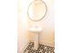 Stylish powder room featuring a pedestal sink, round mirror, and decorative black and white patterned floor tiles at 4305 Huron Dr, Cumming, GA 30028