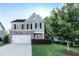 Charming two-story home with a well-manicured lawn, brick accents, and a two-car garage at 4305 Huron Dr, Cumming, GA 30028