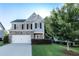 Charming two-story home with brick and gray siding, an attached garage, and a well-maintained lawn at 4305 Huron Dr, Cumming, GA 30028