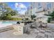 Community pool area featuring outdoor kitchen and tables and chairs under umbrellas at 775 Juniper Ne St # 327, Atlanta, GA 30308