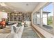 Well-lit living room featuring floor to ceiling bookcases and comfortable seating, creating a cozy library atmosphere at 2996 Treeside Ter, Marietta, GA 30066