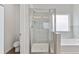 Bright bathroom featuring tiled glass shower, soaking tub, and gray-tiled walls at 3390 Meadow Grass Drive, Dacula, GA 30019