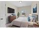 Bedroom with a neatly made bed, dresser, TV, and artwork for a comfortable living space at 3390 Meadow Grass Drive, Dacula, GA 30019