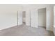 Carpeted bedroom with two doors and a closet, providing ample space and functionality at 3390 Meadow Grass Drive, Dacula, GA 30019