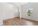 A bright, empty room with wood floors and a window at 3390 Meadow Grass Drive, Dacula, GA 30019