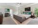Beautifully staged main bedroom with neutral carpet, furniture, and a modern ceiling fan at 3390 Meadow Grass Drive, Dacula, GA 30019