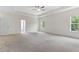 Spacious main bedroom features neutral carpet, large windows, tray ceiling, and a ceiling fan at 3390 Meadow Grass Drive, Dacula, GA 30019