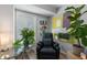 Relaxing sitting area featuring an armchair, plants, decorative painting, window, side table, and warm interior lighting at 46 Ivy Ne Rdg, Atlanta, GA 30342