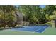 Well-maintained community tennis court with a blue playing surface, surrounded by lush greenery and trees at 46 Ivy Ne Rdg, Atlanta, GA 30342