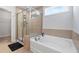 Bright bathroom featuring a soaking tub, tiled walls, and glass-enclosed shower at 55 Clubhouse Way, Acworth, GA 30101
