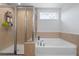 Bright bathroom featuring a soaking tub, tiled walls, and glass-enclosed shower at 55 Clubhouse Way, Acworth, GA 30101