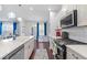 Kitchen with gray cabinets, hardwood floors, stainless steel appliances, and blue curtains at 55 Clubhouse Way, Acworth, GA 30101