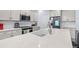 A bright kitchen featuring stainless steel appliances, white cabinets and a large island with a white countertop at 55 Clubhouse Way, Acworth, GA 30101