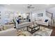 Open-concept living room with hardwood floors, a ceiling fan, and comfortable couches next to a kitchen at 55 Clubhouse Way, Acworth, GA 30101