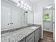 Modern bathroom featuring granite countertops, a large mirror, and elegant fixtures at 3210 Roseheath Ln, Lithonia, GA 30038