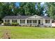 Charming one-story home boasts a well-maintained lawn and inviting front porch at 3210 Roseheath Ln, Lithonia, GA 30038