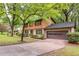 Exterior of a charming home with mature trees, featuring a brick and wood facade and attached garage at 3352 Northbrook Dr, Atlanta, GA 30340