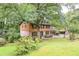 Charming two-story home with brick and wood siding nestled among lush trees, and a sprawling green lawn at 3352 Northbrook Dr, Atlanta, GA 30340