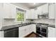 Stylish kitchen showcasing stainless steel appliances, white cabinets, and sleek black countertops at 3977 Fox Glen Dr, Woodstock, GA 30189