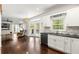 Open concept kitchen/living room with white cabinets, black countertops, and wood floors at 3977 Fox Glen Dr, Woodstock, GA 30189