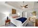 Comfortable main bedroom with tray ceilings, fan, bedside tables, and recliner at 3977 Fox Glen Dr, Woodstock, GA 30189
