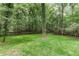 Lush green backyard featuring mature trees, offering privacy and a natural setting at 4806 Deer Chase, Powder Springs, GA 30127