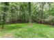 Picturesque backyard featuring a sprawling lawn surrounded by a dense forest, creating a tranquil oasis at 4806 Deer Chase, Powder Springs, GA 30127